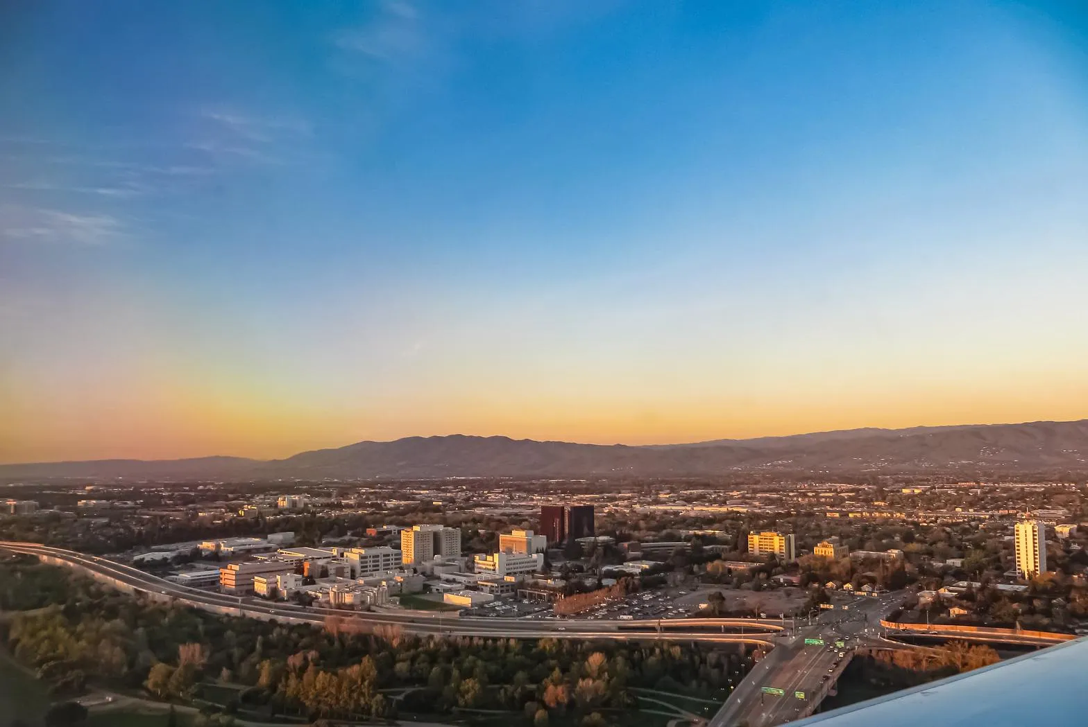 Aerial view of the San Jose valley, downtown skyline, and surrounding hills at sunset